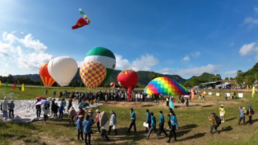 Thousands of tourists watch hot air balloons in the mountain country