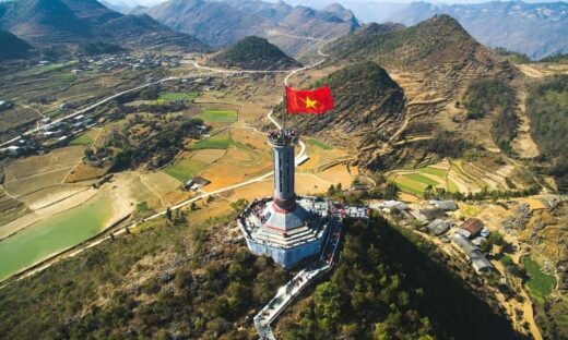 Foreign tourist sits on monument carved with Vietnam's national emblem